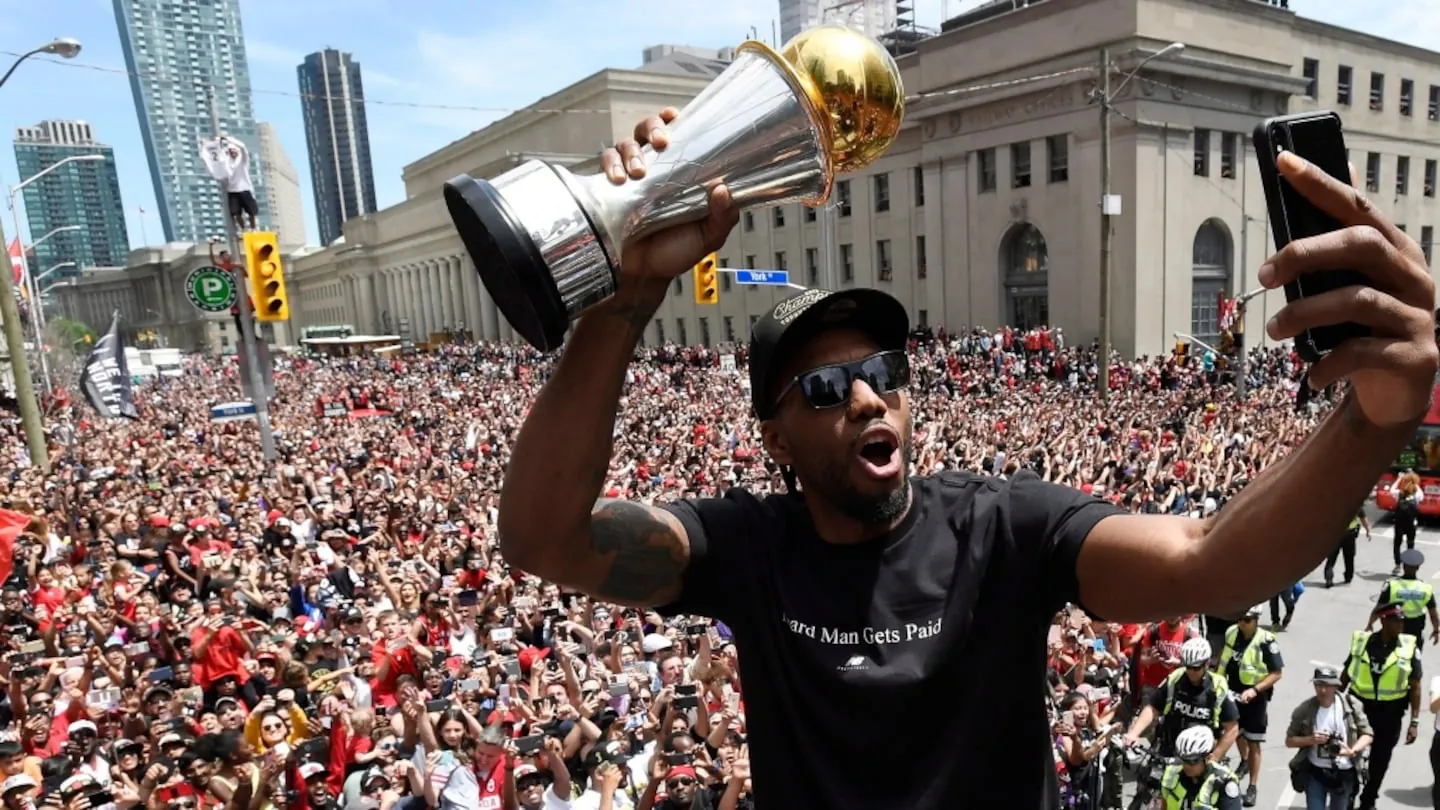 Kawhi LeonardIn this June 17, 2019, file photo, Toronto Raptors forward Kawhi Leonard takes a selfie holding his playoffs MVP trophy during the NBA basketball championship team's victory parade in Toronto. (Frank Gunn/The Canadian Press via AP, File)