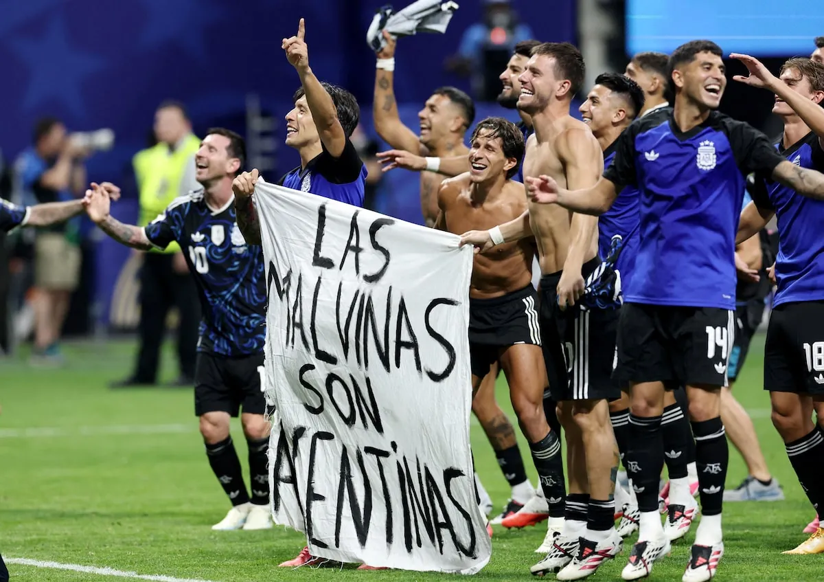 Argentina players hold a banner declaring the Falklands are Argentine as they celebrate their win over England.Amanda Perobelli